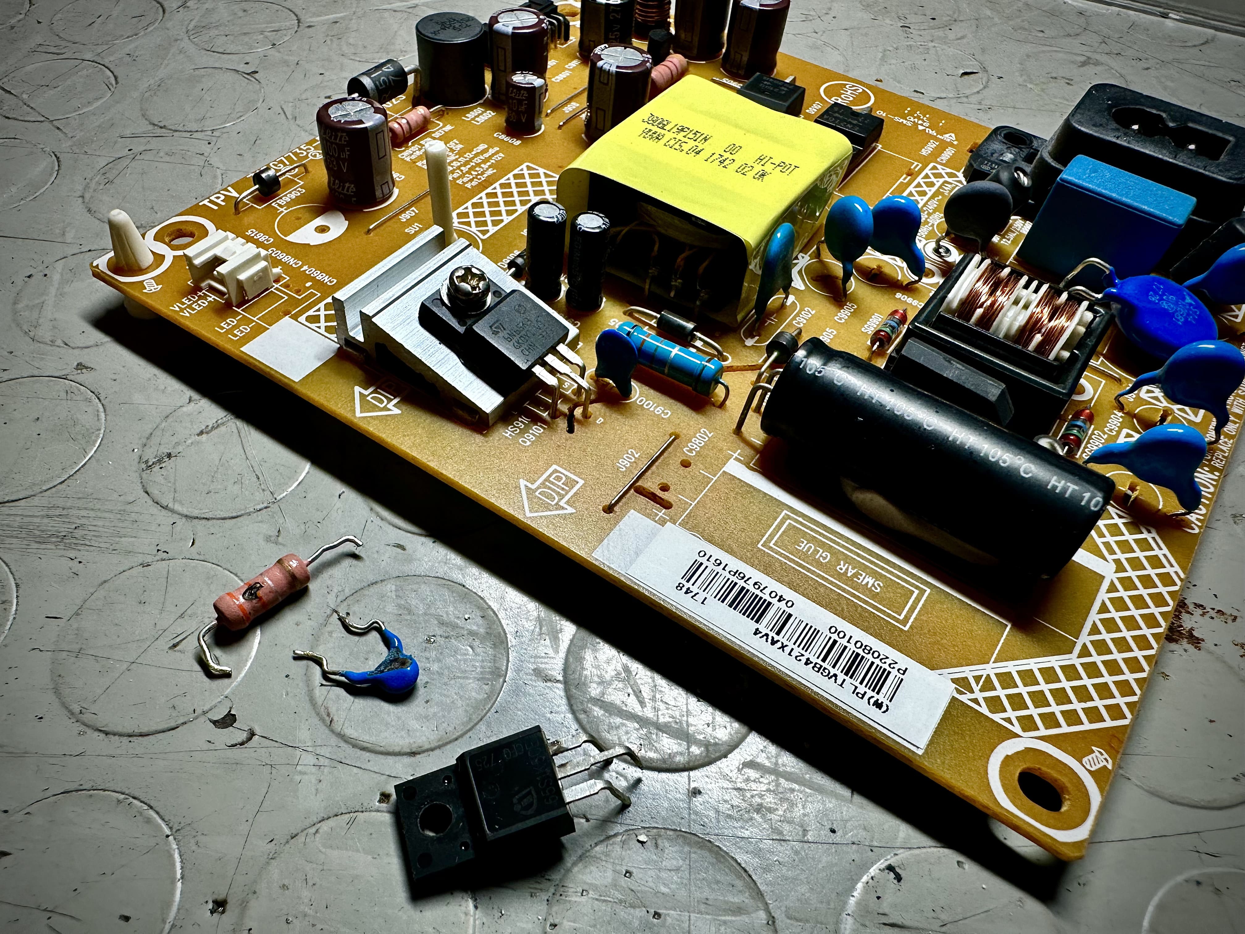 Componenti elettronici guasti rimossi dalla PSU del TV Philips 22PFS4022 durante la riparazione